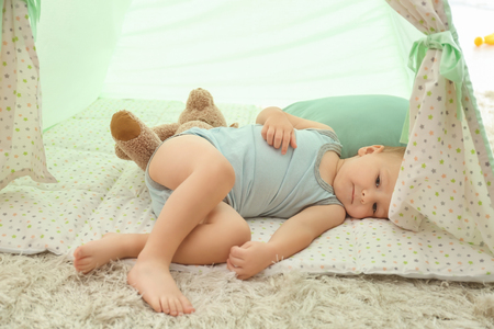 Cute little boy lying on floor indoorsの写真素材