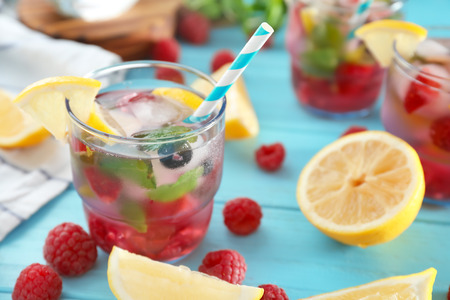 Glass of fresh raspberry mojito on wooden tableの写真素材