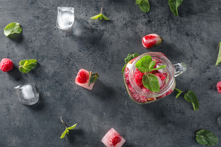 Mason jar of fresh raspberry mojito on dark tableの写真素材