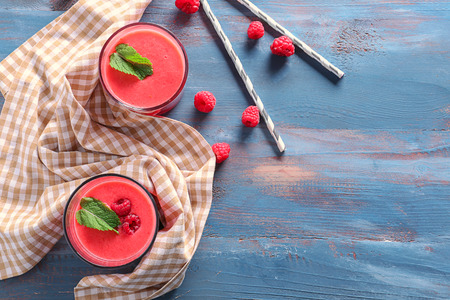 Glasses of tasty raspberry smoothie on wooden table, top viewの写真素材