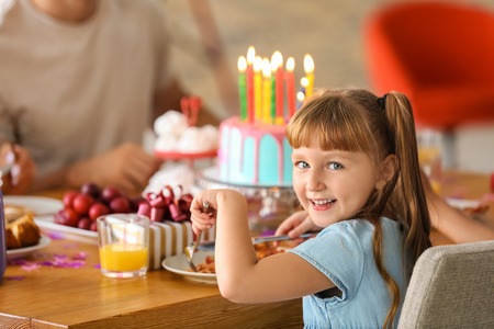 Cute little girl eating tasty pizza at birthday partyの写真素材