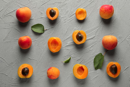 Ripe sweet apricots on grey textured background, flat layの写真素材