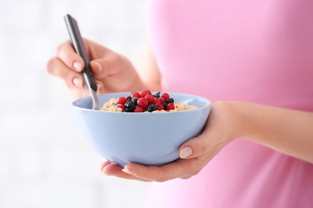 Woman with bowl of tasty oatmeal, closeupの写真素材