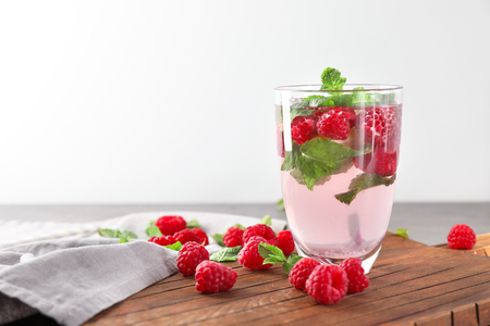 Glass of fresh raspberry mojito on boardの写真素材