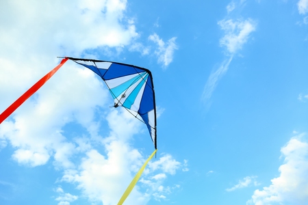 Colorful kite flying in blue skyの写真素材