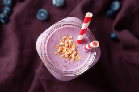 Glass jar of tasty blueberry smoothie on tableの写真素材