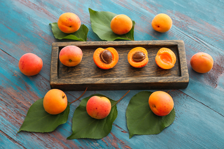 Plate with ripe sweet apricots on wooden tableの写真素材