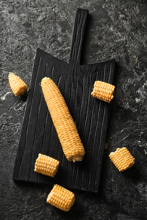 Fresh corn cobs on wooden boardの写真素材
