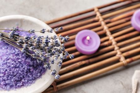 Bowl with sea salt for spa and lavender on bamboo mat, closeupの写真素材