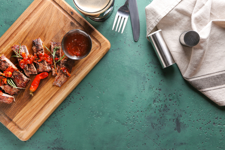 Cut grilled steak with sauce on color tableの写真素材