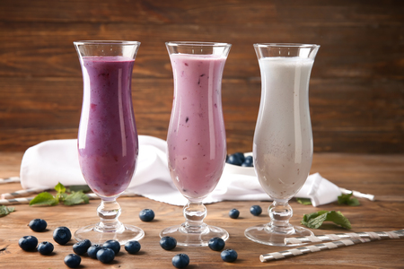Glasses of tasty blueberry smoothie on wooden tableの写真素材