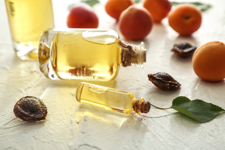 Bottles with apricot essential oil on tableの写真素材