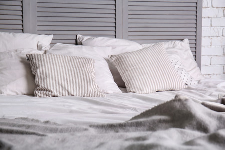 Bed with soft pillows in room