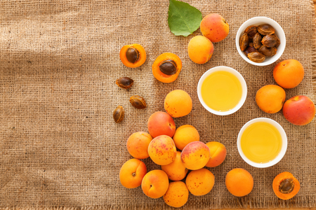 Bowls with essential oil and fresh apricots on tableの写真素材
