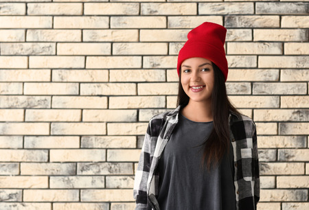 Beautiful young woman on brick wall backgroundの写真素材
