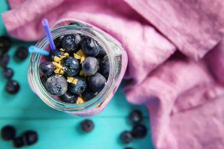 Glass jar with tasty blueberry smoothie on color wooden table, top viewの写真素材