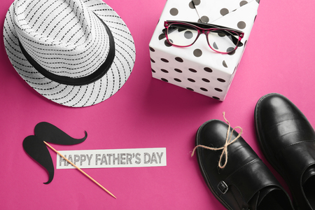 Male accessories, gift box and paper with text HAPPY FATHER'S DAY on color backgroundの写真素材