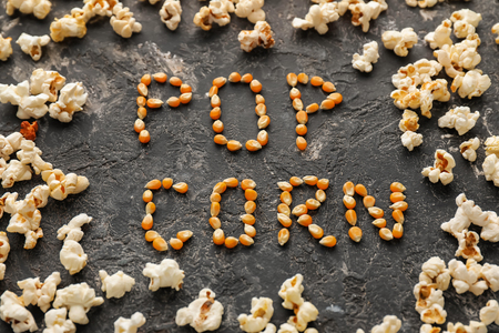 Delicious popcorn and words made of kernels on grunge tableの写真素材