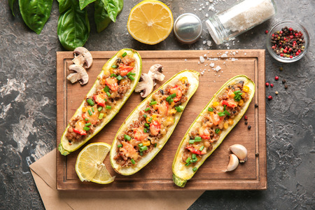 Board with meat stuffed zucchini boats and spices on grunge tableの写真素材