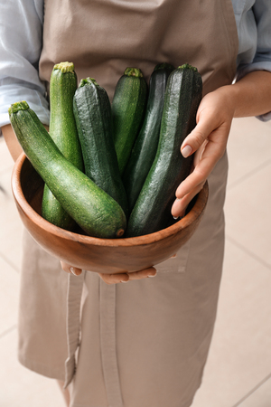 Woman holding bowl with fresh zucchini, closeupの写真素材