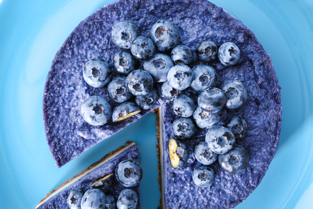 Tasty cheesecake with blueberries on plate, closeup
