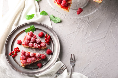 Plate with pieces of delicious raspberry cheesecake on tableの写真素材