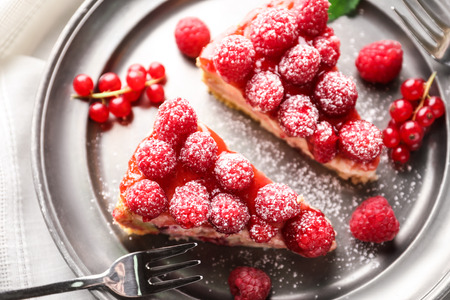 Pieces of delicious raspberry cheesecake on plate, closeup