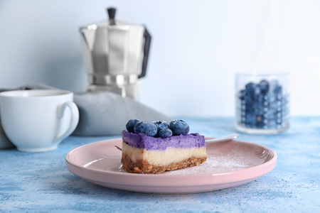 Plate with delicious blueberry cheesecake on light tableの写真素材