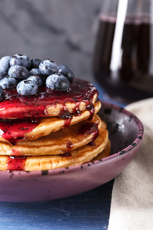 Bowl with tasty pancakes, jam and blueberries on table, closeupの写真素材