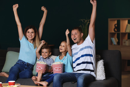 Happy family watching TV in eveningの写真素材