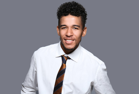 Handsome African-American businessman on grey backgroundの写真素材