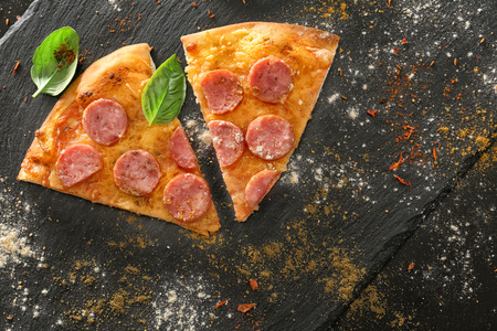 Slices of tasty pizza on dark backgroundの写真素材