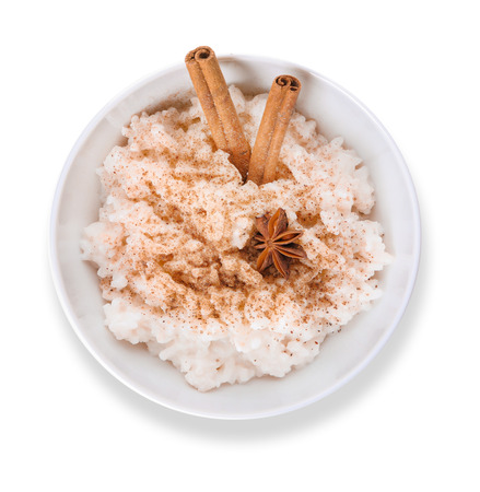 Bowl with delicious rice pudding and cinnamon powder on white backgroundの写真素材