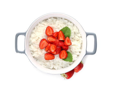Pot with delicious rice pudding and strawberry on white backgroundの写真素材