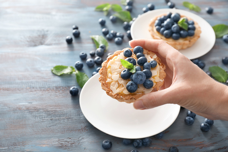 Woman taking blueberry tart from plate, closeupの写真素材