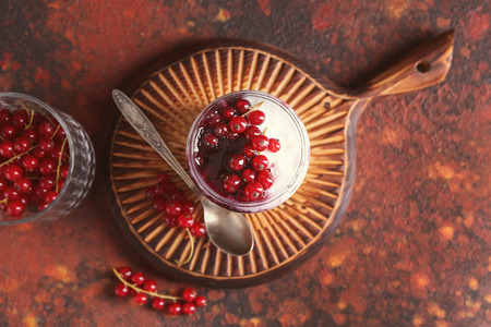 Glass jar with delicious rice pudding and currants on boardの写真素材