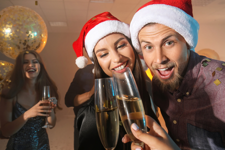 Young people with glasses of champagne at Christmas partyの写真素材