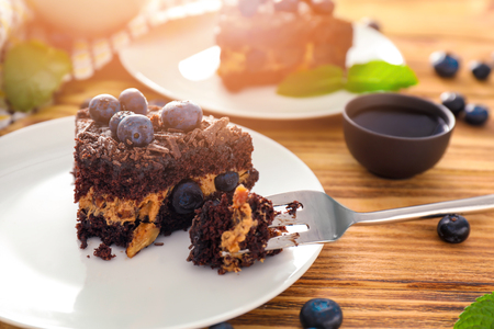 Plate with piece of blueberry chocolate cake on wooden table, closeupの写真素材