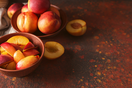 Bowls with fresh peaches on tableの写真素材