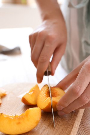 Woman cutting fresh sweet peaches, closeupの写真素材
