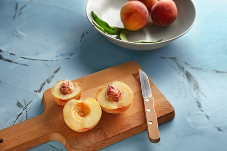 Board with fresh peaches on light tableの写真素材