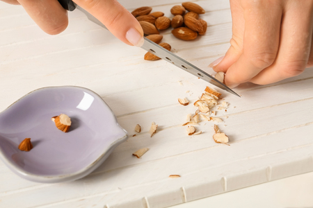 Woman cutting nuts on board, closeupの写真素材