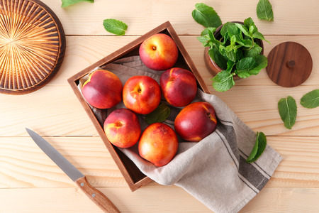 Wooden box with fresh sweet peaches on tableの写真素材