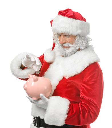 Santa Claus putting coin into piggy bank on white backgroundの写真素材