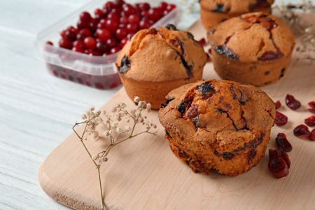 Tasty cranberry muffins on boardの写真素材