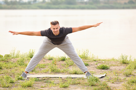 Sporty young man training outdoors near riverの写真素材