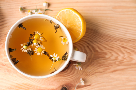 Cup of delicious camomile tea on wooden tableの写真素材
