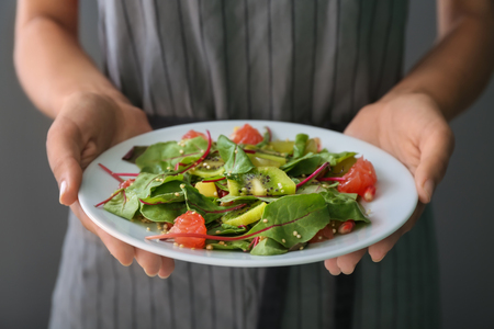 Woman holding plate with healthy fresh salad, closeupの写真素材