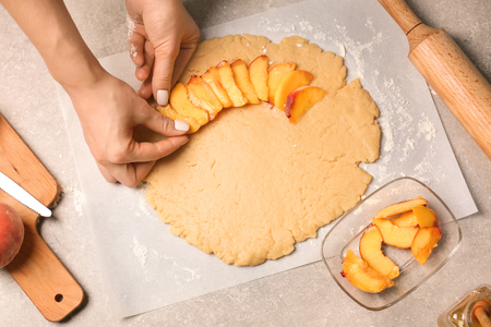 Woman preparing peach galetteの写真素材