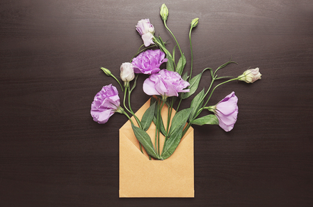 Open mail envelope with eustoma flowers on dark backgroundの写真素材